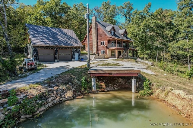 exterior space featuring a garage and a water view