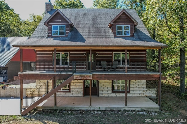 exterior space featuring a wooden deck and a patio