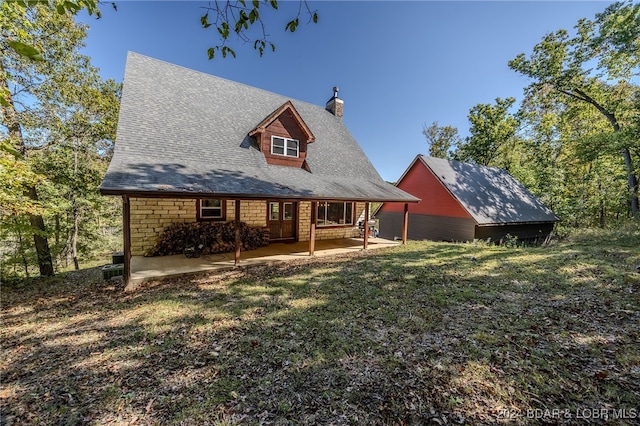 rear view of house featuring a yard and a patio