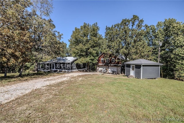 exterior space featuring a garage, an outdoor structure, and a front yard