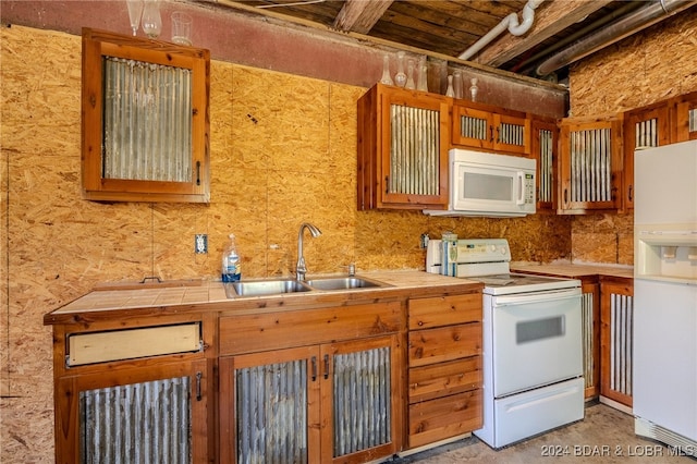 kitchen with white appliances, tile counters, and sink