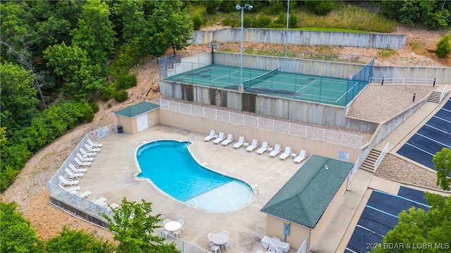 view of pool with a patio and tennis court