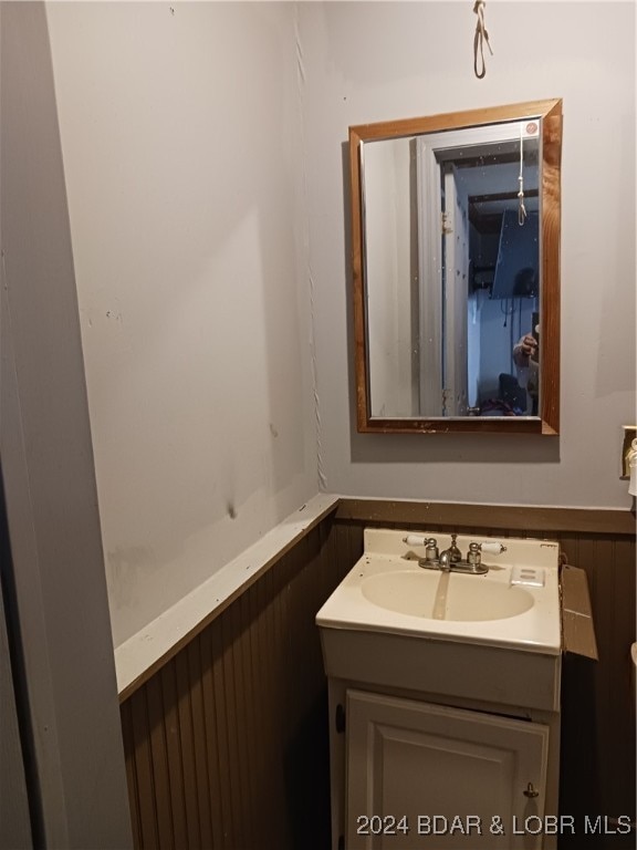 bathroom featuring wood walls and vanity