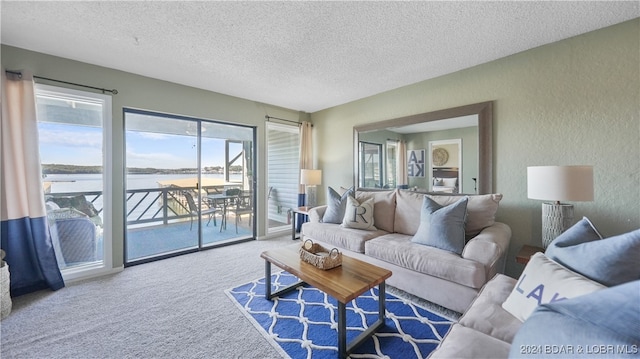 living room featuring a textured ceiling, a water view, and carpet flooring