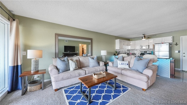 living room with carpet floors, a textured ceiling, and ceiling fan