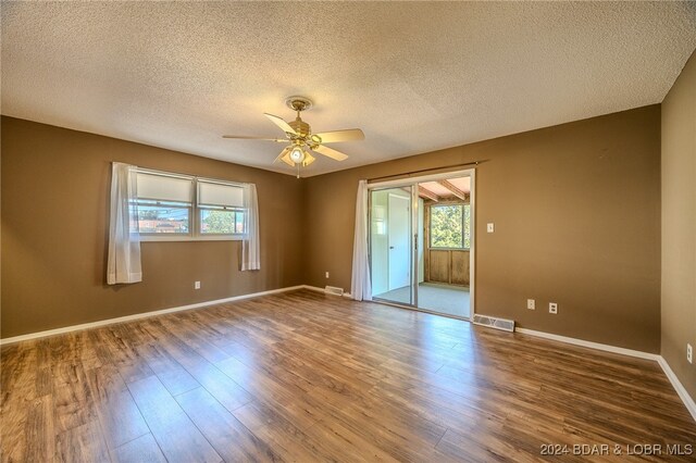 spare room with a textured ceiling, hardwood / wood-style floors, and ceiling fan