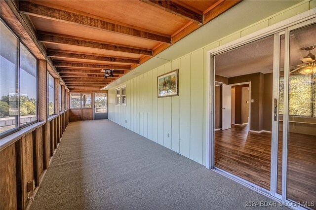 unfurnished sunroom featuring beamed ceiling