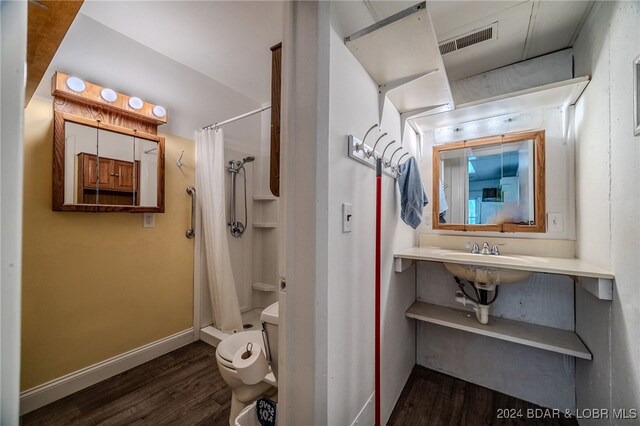 bathroom with wood-type flooring, toilet, and a shower with shower curtain