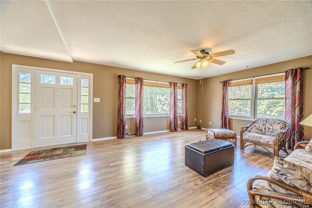 living room with ceiling fan, light hardwood / wood-style flooring, and plenty of natural light