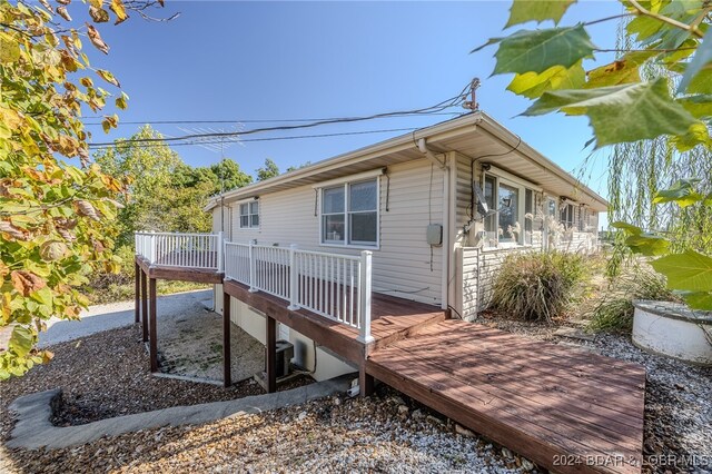 view of property exterior with a wooden deck