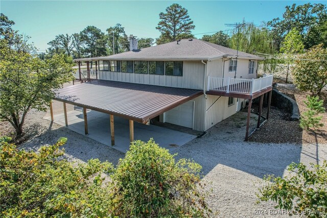 rear view of property featuring a deck and a garage