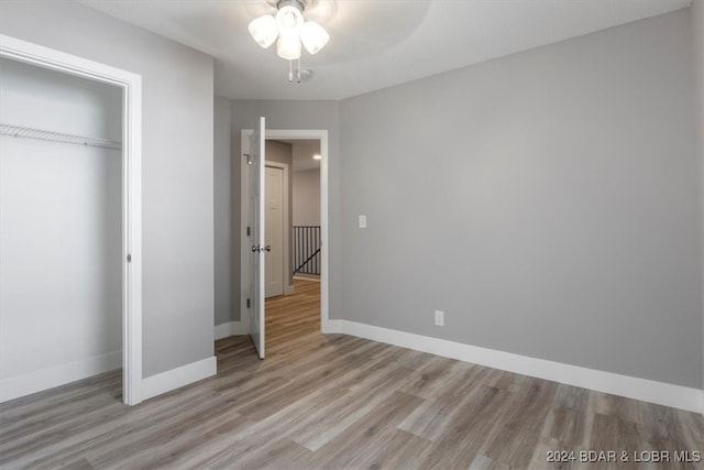 unfurnished bedroom with ceiling fan, a closet, and light hardwood / wood-style flooring