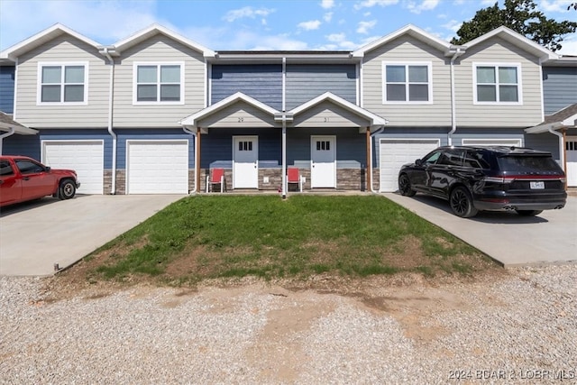 multi unit property with a garage and a front yard