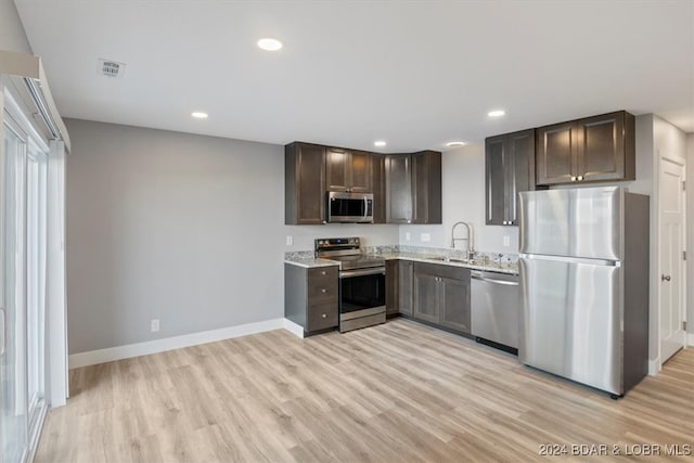 kitchen featuring dark brown cabinets, sink, stainless steel appliances, and light hardwood / wood-style floors