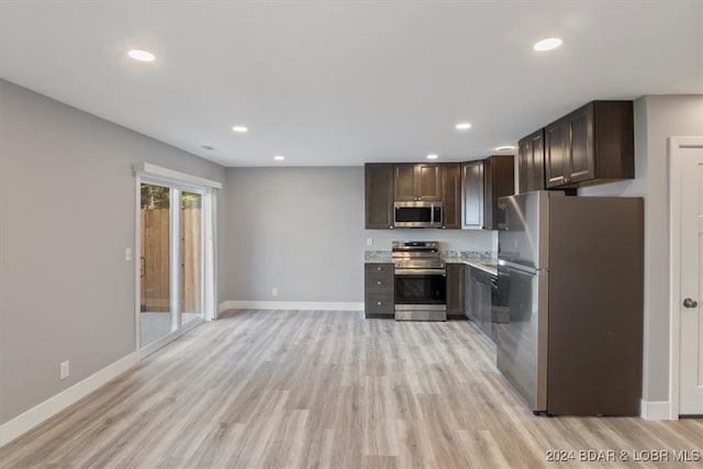 kitchen with dark brown cabinets, appliances with stainless steel finishes, and light hardwood / wood-style floors