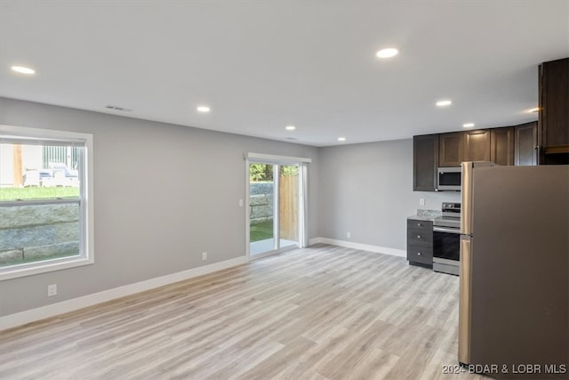 kitchen featuring dark brown cabinetry, appliances with stainless steel finishes, and light wood-type flooring