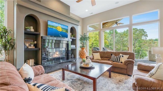 sunroom / solarium with a fireplace and ceiling fan