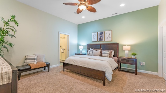 bedroom with light carpet, connected bathroom, and ceiling fan