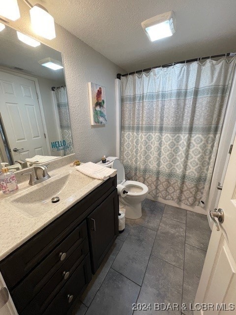 full bathroom featuring vanity, a textured ceiling, shower / tub combo, tile patterned floors, and toilet