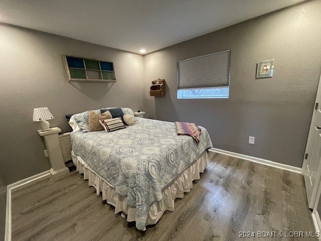 bedroom with dark wood-type flooring