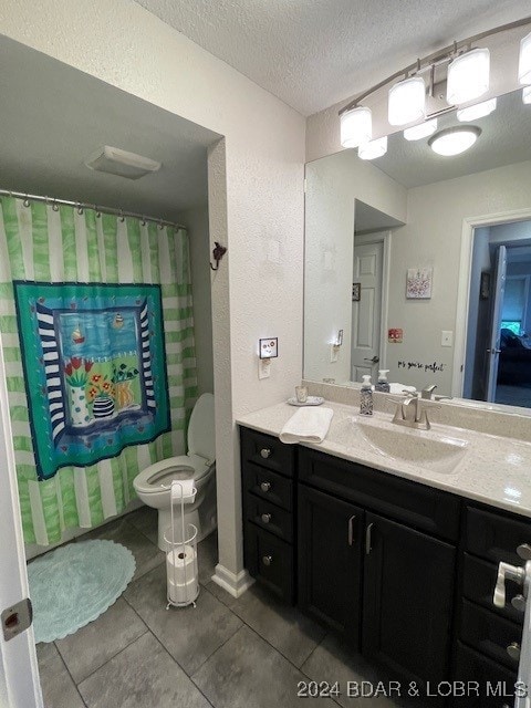 bathroom featuring vanity, a textured ceiling, tile patterned floors, walk in shower, and toilet