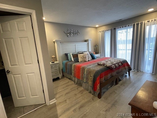 bedroom featuring a textured ceiling and hardwood / wood-style flooring