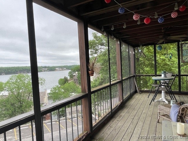 sunroom with a wealth of natural light and a water view