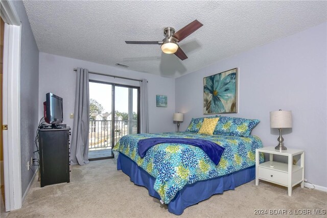 carpeted bedroom with ceiling fan, access to outside, and a textured ceiling