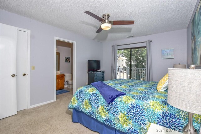 carpeted bedroom with access to outside, a textured ceiling, ensuite bathroom, and ceiling fan