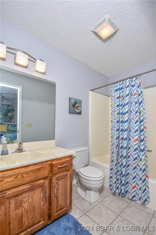 full bathroom with shower / tub combo, vanity, a textured ceiling, tile patterned flooring, and toilet