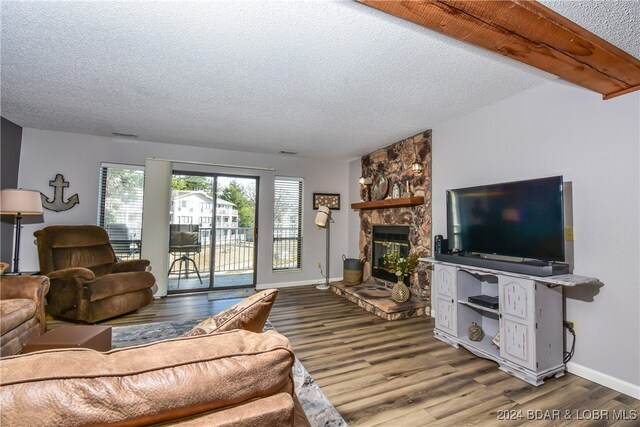 living room featuring a textured ceiling, a fireplace, and hardwood / wood-style floors