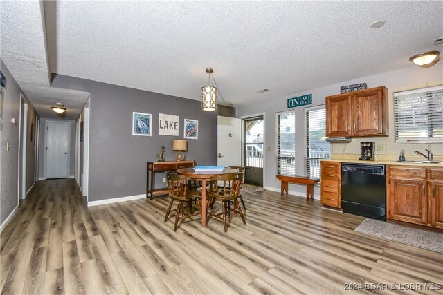 dining area featuring light wood-type flooring, a textured ceiling, and sink