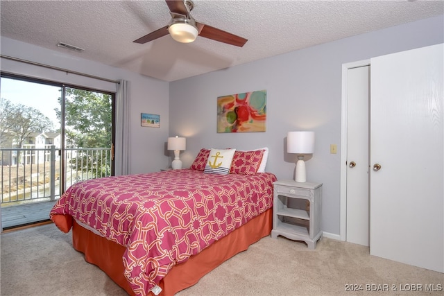 bedroom featuring a textured ceiling, ceiling fan, light colored carpet, and access to exterior