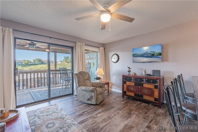 sitting room featuring wood-type flooring, ceiling fan, and a textured ceiling