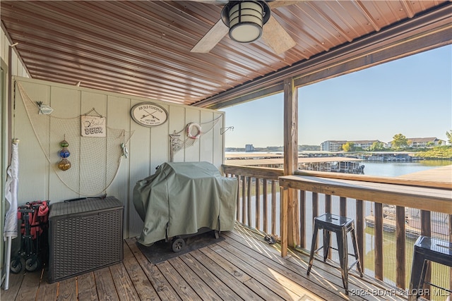 wooden terrace with a grill, ceiling fan, and a water view