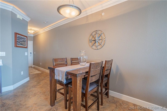 dining room featuring crown molding and baseboards