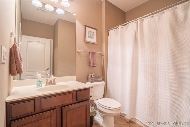 bathroom featuring a shower with shower curtain, toilet, vanity, and tile patterned floors