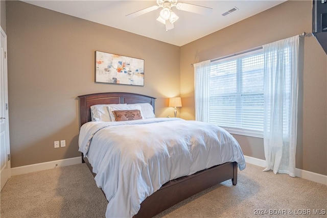 bedroom featuring light carpet, ceiling fan, visible vents, and baseboards