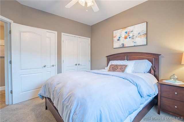 bedroom featuring a ceiling fan, carpet, and two closets