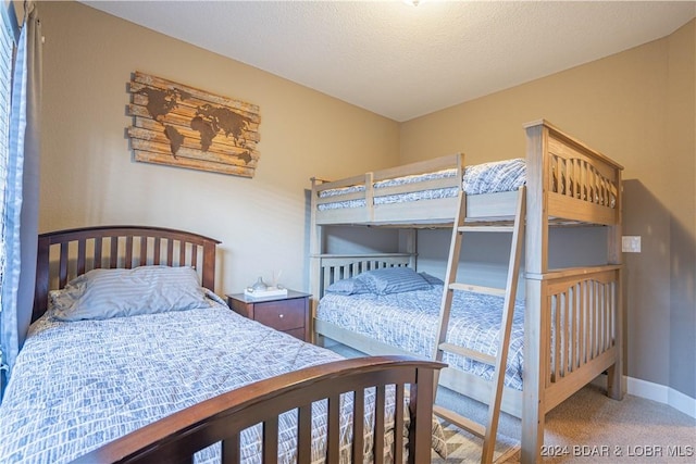 carpeted bedroom with a textured ceiling and baseboards