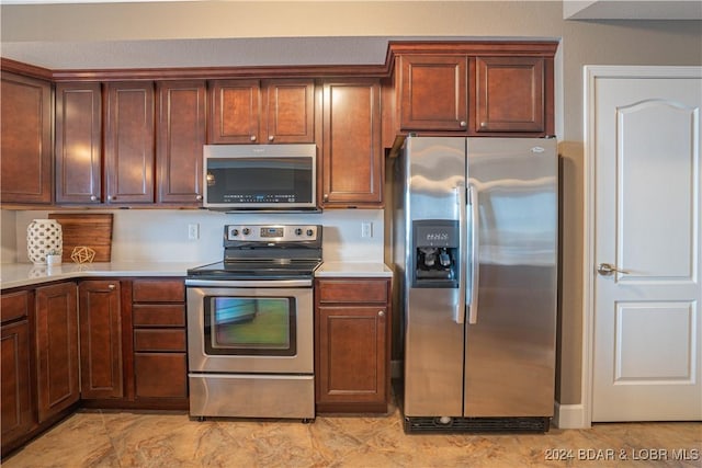 kitchen featuring stainless steel appliances, light countertops, and brown cabinets