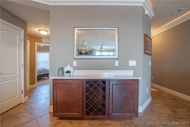 bar featuring baseboards, crown molding, visible vents, and light tile patterned floors