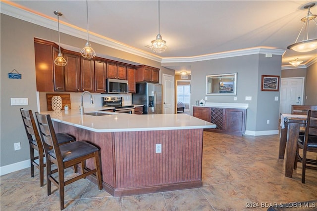 kitchen with decorative light fixtures, a peninsula, stainless steel appliances, light countertops, and a sink