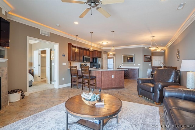 living room featuring visible vents, a fireplace, and ornamental molding