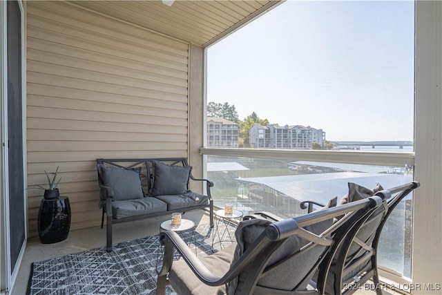 balcony with ceiling fan and a water view