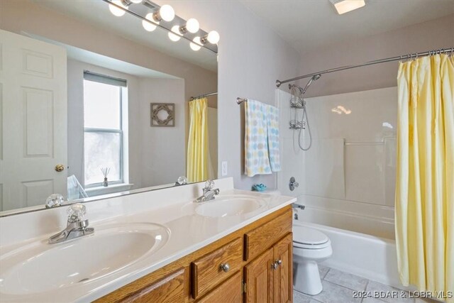 full bathroom featuring shower / bath combo with shower curtain, tile patterned flooring, vanity, and toilet