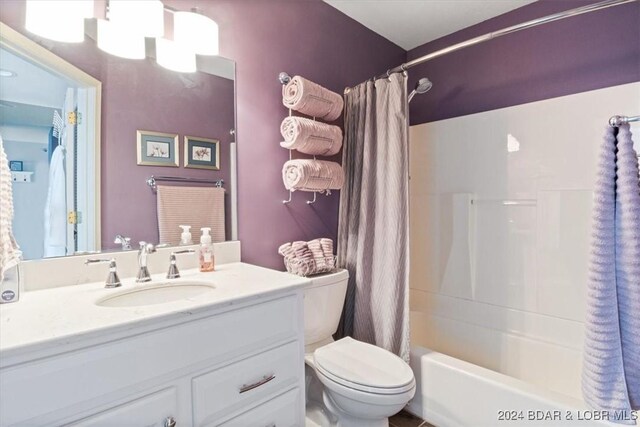 full bathroom with vanity, shower / bath combo, and toilet