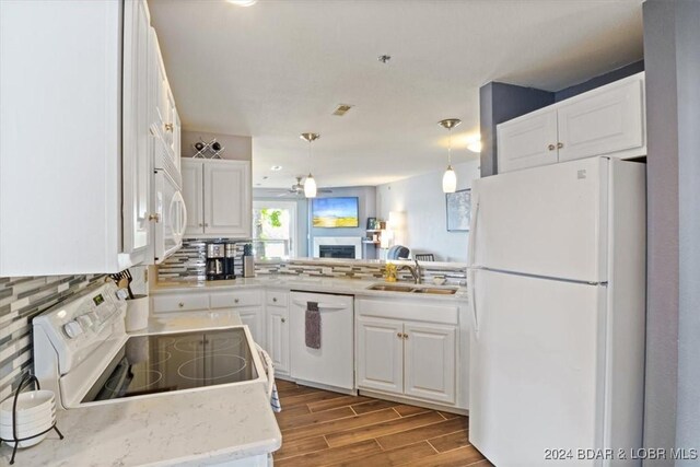 kitchen featuring pendant lighting, white appliances, white cabinetry, and sink