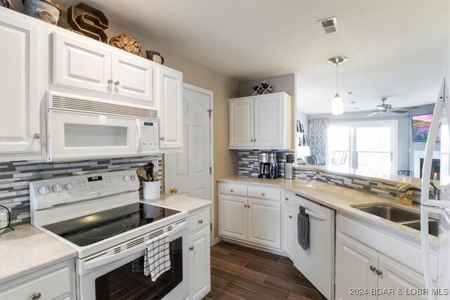 kitchen with white cabinets, white appliances, hanging light fixtures, and sink