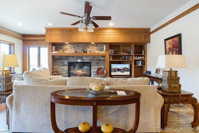 living room with ceiling fan, ornamental molding, and a fireplace